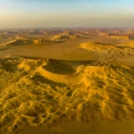 The two cars of our camp are nestled in between the dunes in the foreground