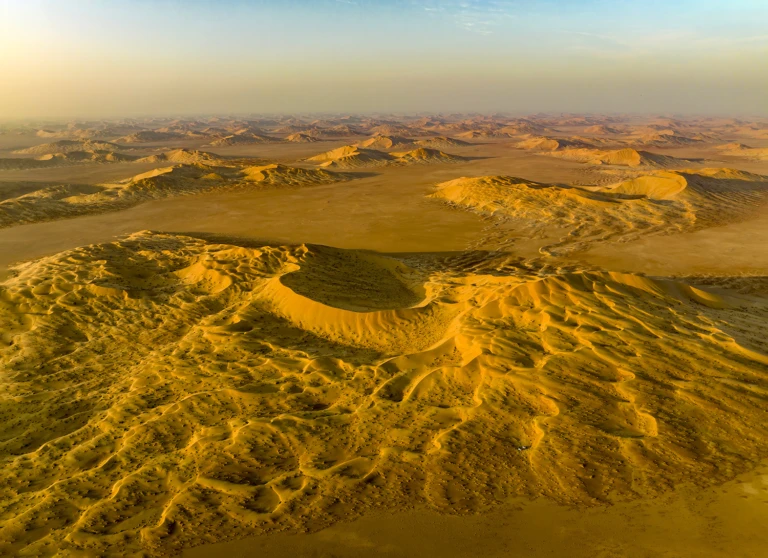 The two cars of our camp are nestled in between the dunes in the foreground