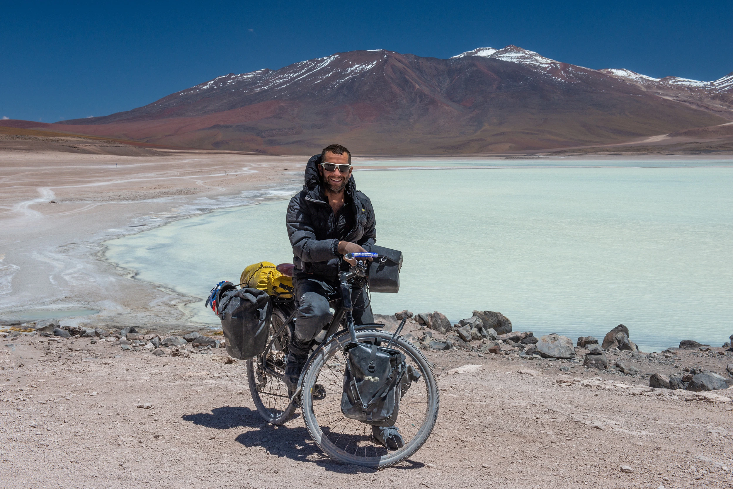 World traveler in front of Laguna verde, Chile – photo by Reiner Boehme
